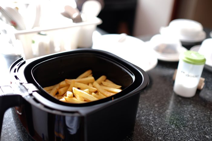 Home-made french fries in modern airfryer, DIY home food concept
