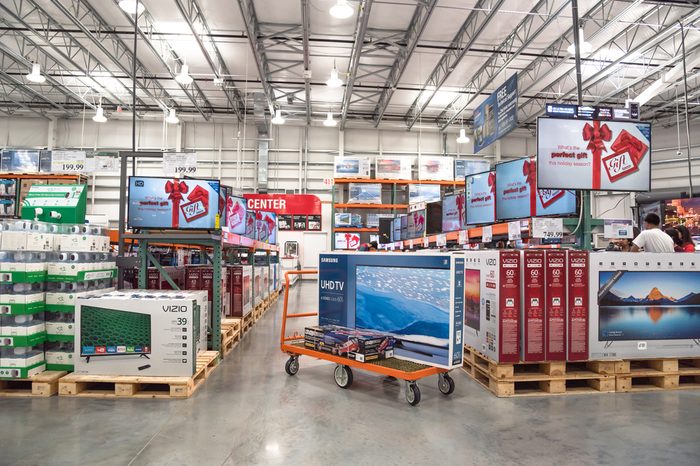HUMBLE, TX, US-NOV 25, 2016: Costco Wholesale with row of big screen, smart TVs display on shelves and on flatbed cart. It is the largest membership-only warehouse club in US. Customer shopping.