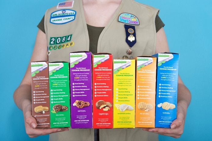 Girl scout holding cookie boxes