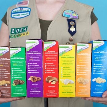 Girl scout holding cookie boxes