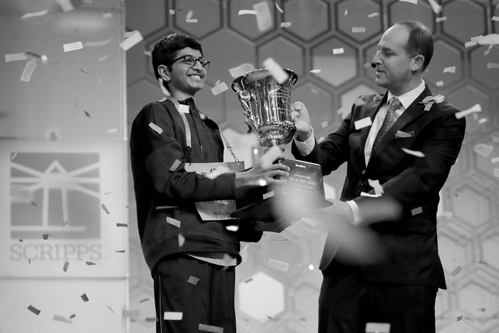 Karthik Nemmani (L) poses with the championship trophy and E.W. Scripps Company CEO Adam Symson after Nemmani correctly spelled the word 'koinonia' to win the 91st Scripps National Spelling Bee at the Gaylord National Resort and Convention Center May 31, 2018 in National Harbor, Maryland.