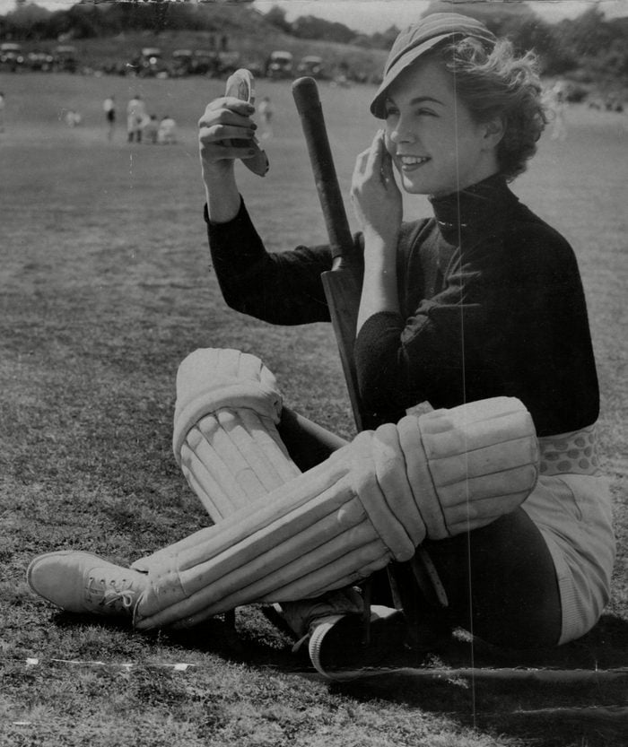 Diana Ferry Of The Lucy Clayton Cricket Team Adjusting Her Make Up During A Cricket Match Against A Men's Team In The Village Of Puttenham.