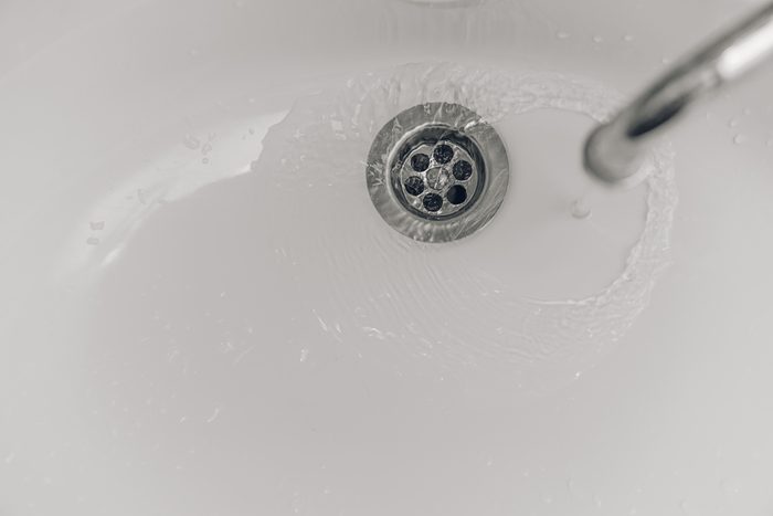 Drain water in the white sink in the bathtub