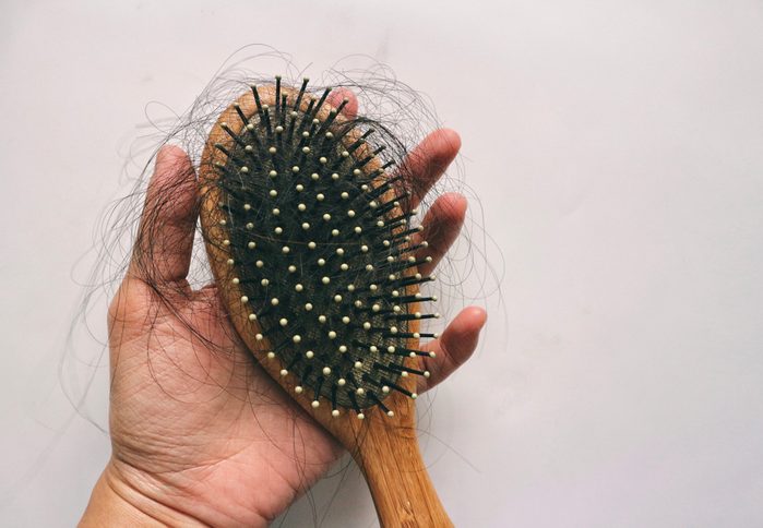 Hair loss inside wood comb brush, on hand