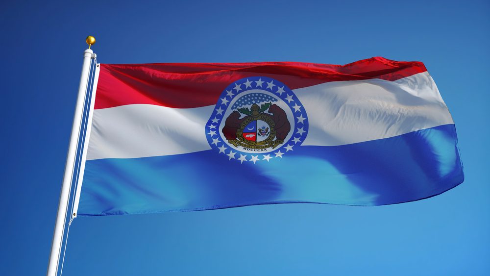 Missouri (U.S. state) flag waving against clear blue sky, close up, isolated with clipping path mask alpha channel transparency, perfect for film, news, composition