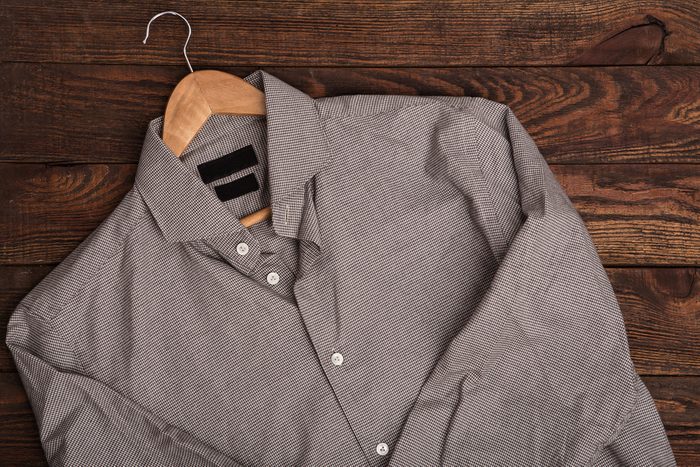 Business classic men's shirt with houndstooth pattern print. Casual outfit on brown wooden grunge background