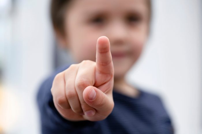 Blurry face of little boy finger pointing at camera, Selective focus of kid primary school boy pointing at you with his finger, Spoiled children concept