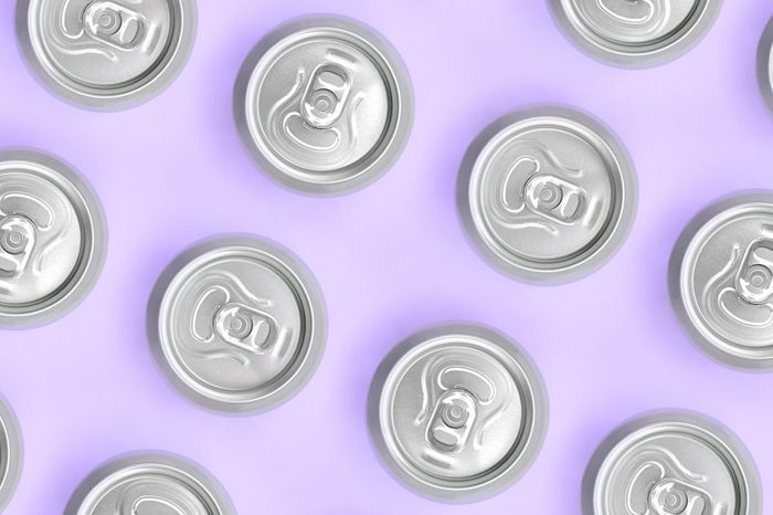 Many metallic beer cans on texture background of fashion pastel violet color paper in minimal concept