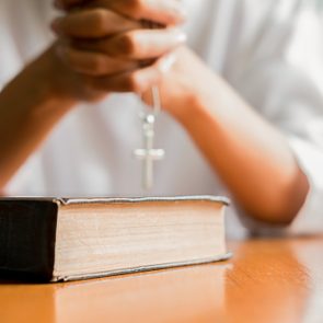 Christian woman praying on holy bible. Hands folded in prayer a holy bible in church concept