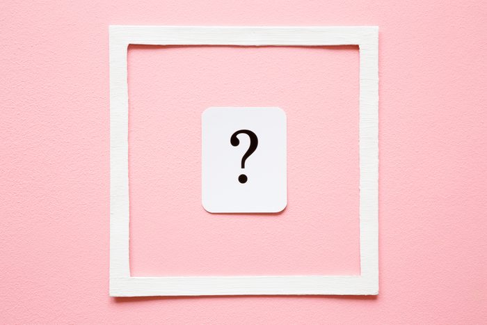 Card of question mark in white frame on pastel pink background. Soft light color. Women issues. Problem and solution concept.