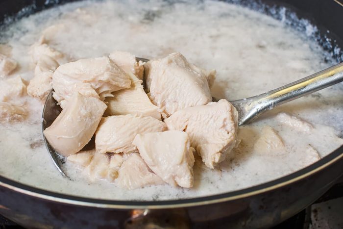 Boiled chicken breast in a pan on the sieve
