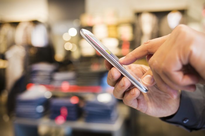 Close up of a man using Smart-Phone in clothing store