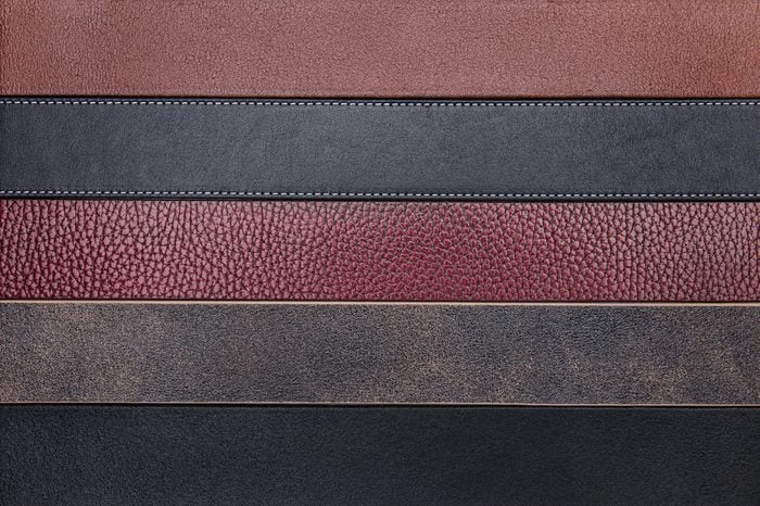 Dark natural leather belts close-up texture background