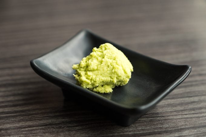 Wasabi in brown dish on wood table. Sauce for Japanese food.