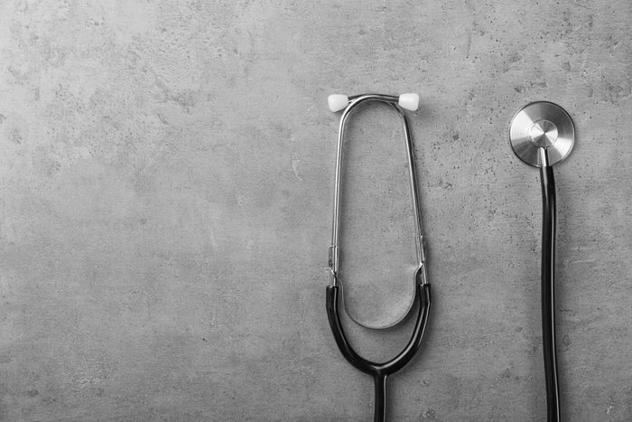 Stethoscope for checking pulse and space for text on gray background, top view
