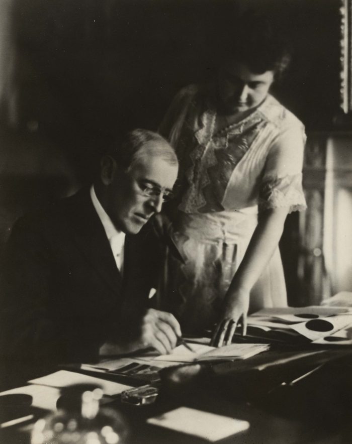 Various June 1920 - President Woodrow Wilson, seated at desk with his wife, Edith Bolling Galt, standing at his side