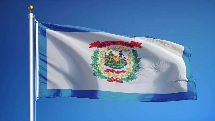 West Virginia (U.S. state) flag waving against clear blue sky, close up, isolated with clipping path mask alpha channel transparency, perfect for film, news, composition
