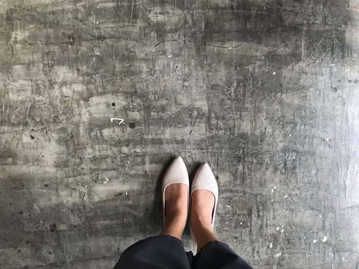 Top view shot everyday look of women wear basic long black trousers and classic beige flat shoes. (Shoe selfie concept)