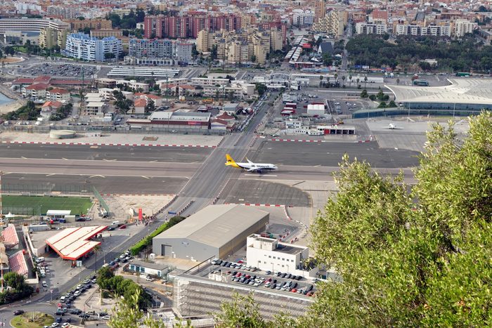 GIBRALTAR - AUGUST 29, 2017: City of Gibraltar, the airport runway with a landed Monarch airplane and La Linea de la Concepcion in Spain.