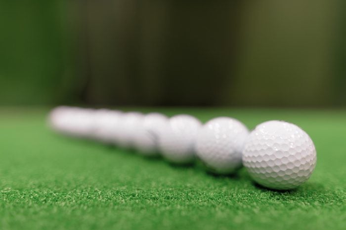 Close Up Shot Of Golf Balls Scattered Around On Green Surface