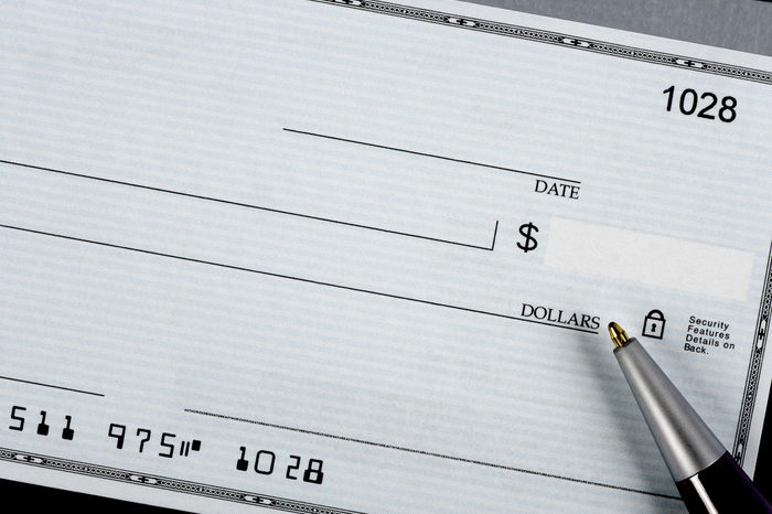 A closeup of a bank check with a pen.