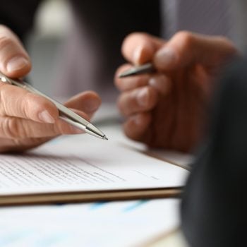 Male arm in suit and tie fill form clipped pad with silver pen closeup. Sign gesture read pact sale agent bank job make note loan credit mortgage investment finance executive chief legal teamwork law