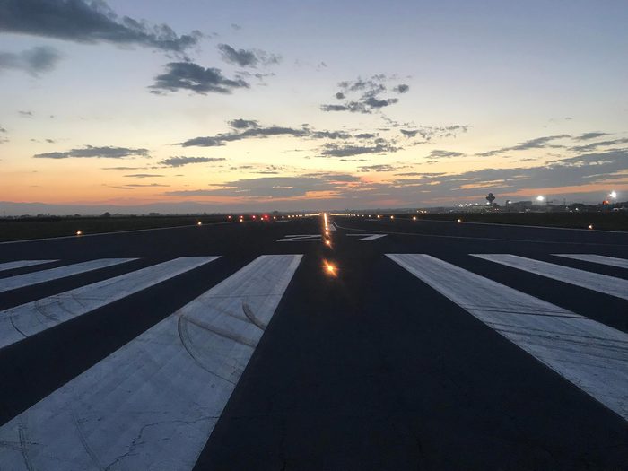 Photos of Airport Runways at twilight, showing runway markings, runway lights, clear skies and mountains in the horizon