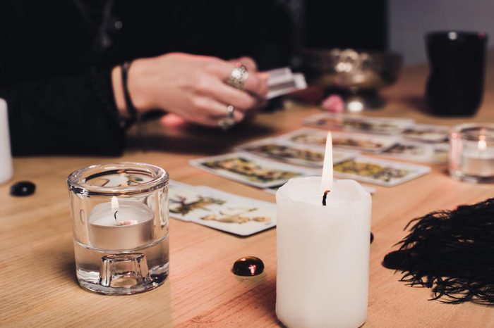 selective focus of burning candles with female psychic on background
