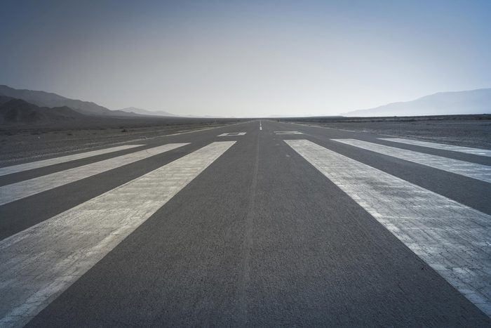 Long paved runway shot from its threshold markings