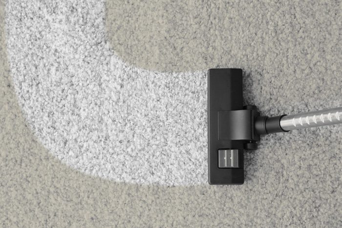 Vacuum cleaner removing dirt from carpet
