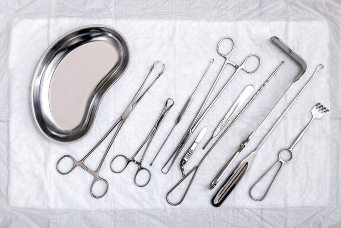 Gynecological sterile tools. A lot of instruments of gynecologist on white background. Top view.