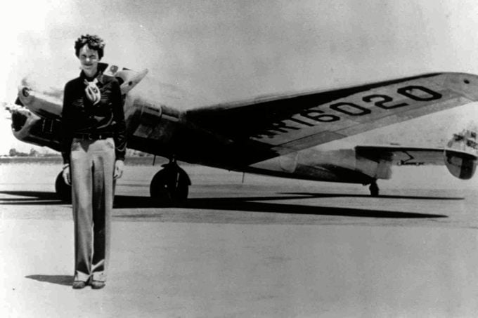 Amelia Earhart, 40, stands next to a Lockheed Electra 10E
