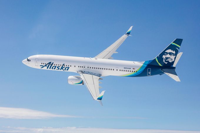 Alaska Airlines Plane in flight against a blue sky