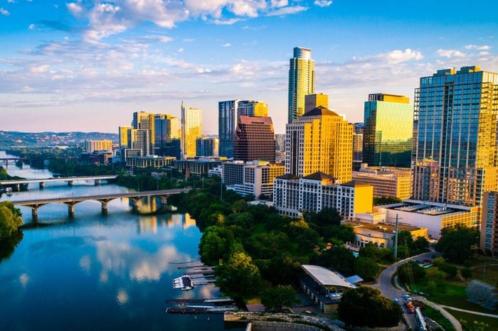 Panoramic sunrise aerial drone view over Lady Bird Lake in Austin Texas the capital city glowing under Morning golden hour sunrise