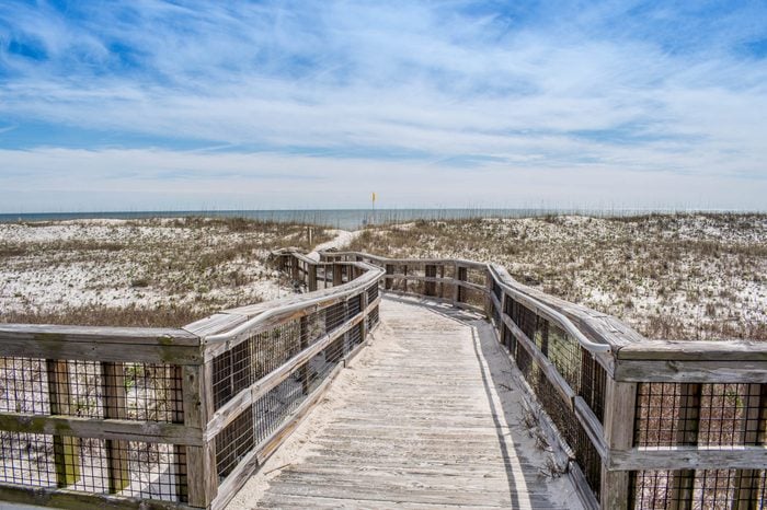 A very long boardwalk surrounded by shrubs in Perdido Key State Park, Florida