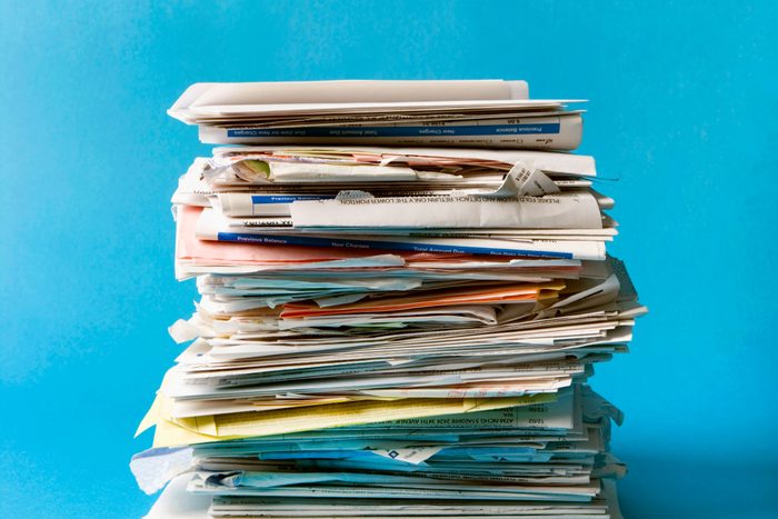 stack of junk mail on a blue background
