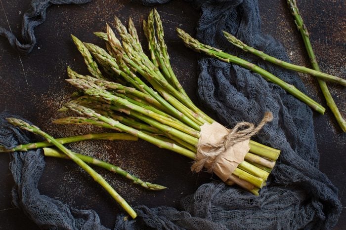 Fresh raw asparagus spears on a dark table
