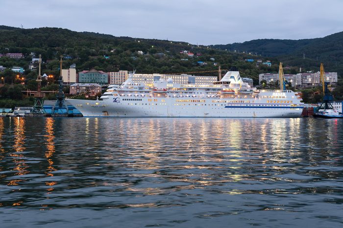 AVACHA BAY, KAMCHATKA PENINSULA, RUSSIAN FAR EAST - 4 SEPTEMBER, 2018: Picturesque night view of white Japanese cruise liner Pacific Venus anchored at pier in Petropavlovsk-Kamchatsky Seaport.