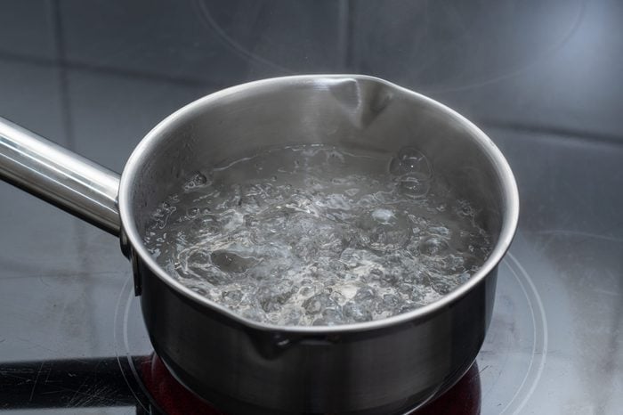 Boiling water in pan in kitchen - hot bowl water