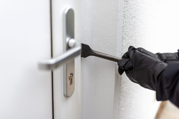 Burglar tries to open a front door with crowbars