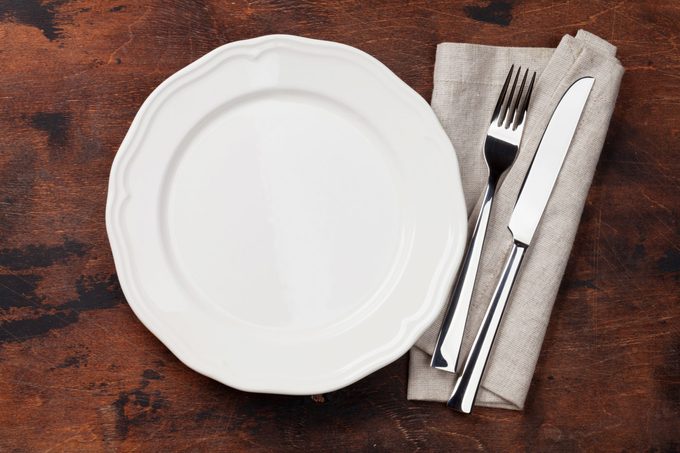 Table setting. Empty plate, knife, fork and napkin. Top view and flat lay with copy space