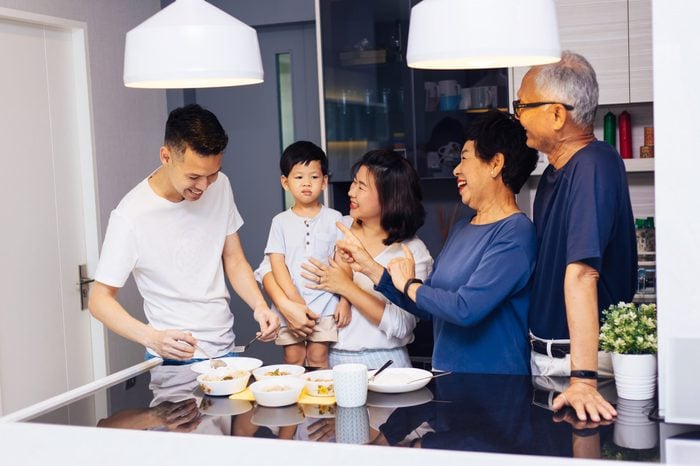 Happy Asian extended family preparing food at home full of laughter and happiness