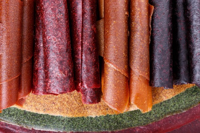 Colorful fruit leather rolls on mats of crushed fruit ( tklapi ). Fruit candy - pastille. Top view.
