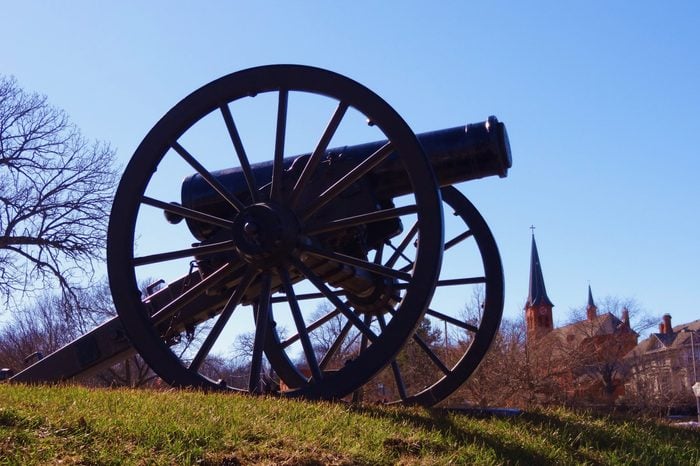 historic war cannon on a grass covered hill with church in background Stillwater Minnesota 