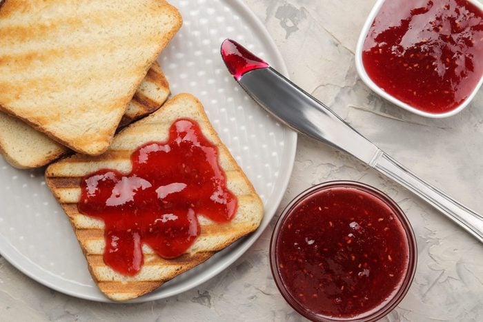 toasts with jam. fried crispy toasts with red jam on a light concrete table. breakfast. top view