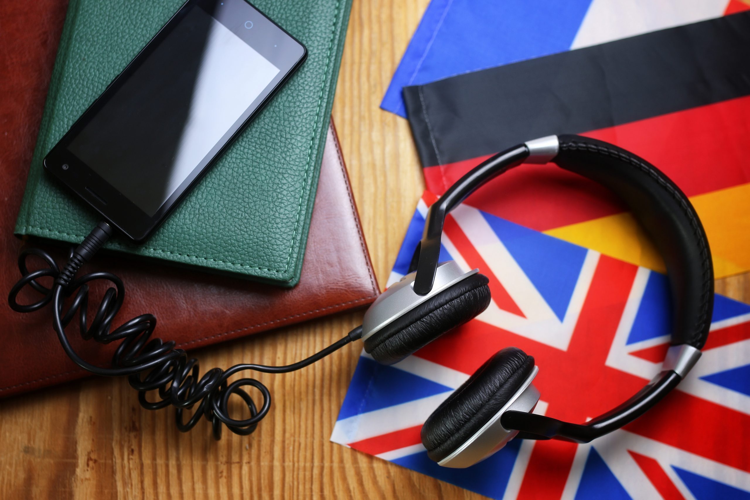 headphones and flag on a wooden background concept course language 