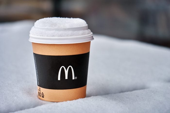 Obninsk, Russia - January 4,2019. Mcdonald's paper cup of coffee standing on the table covered with snow outdoors in winter
