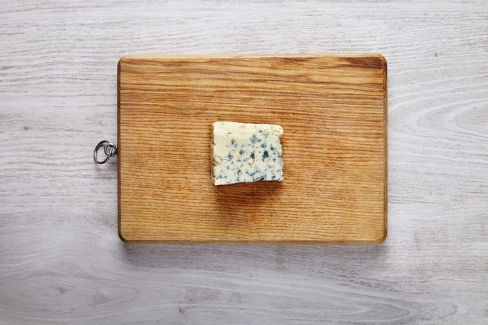 One piece of fresh roquefort cheese on wooden board