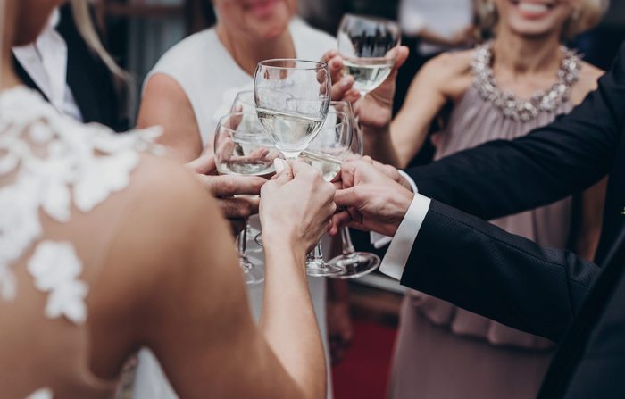 christmas luxury celebration feast. champagne and wine glasses in hands at luxury wedding reception at restaurant. guests toasting and cheering at stylish celebration. space for text