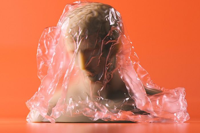 3d rendering of bust statue with cellophane wrap on orange background. Subsurface scattering marble material